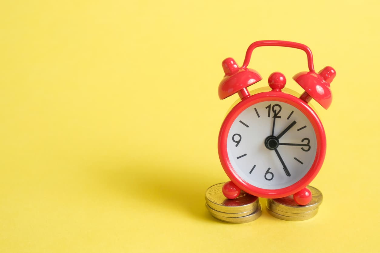 Alarm clock standing on coins